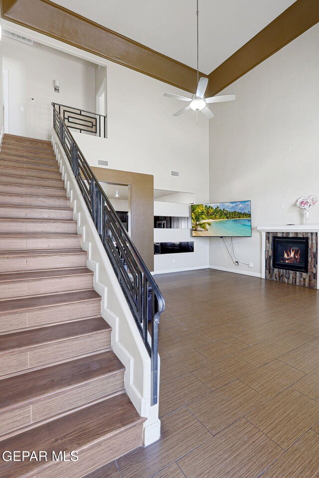 12748 Barstow Ave, El Paso, TX 79928 - staircase with a glass covered fireplace, ceiling fan, and a towering ceiling