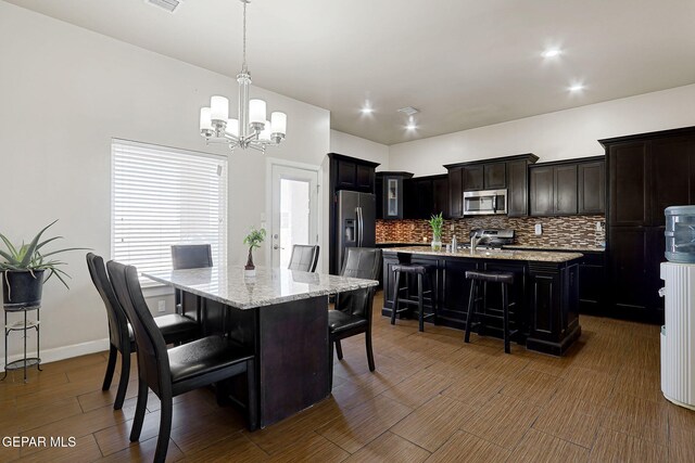 12748 Barstow Ave, El Paso, TX 79928 - dining space with a chandelier, dark wood-style floors, and baseboards