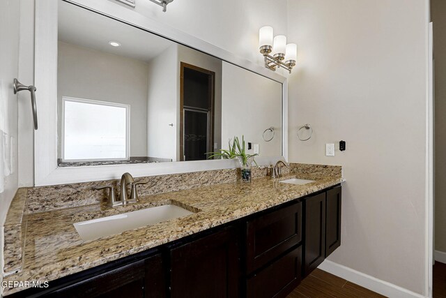 12748 Barstow Ave, El Paso, TX 79928 - bathroom featuring baseboards, double vanity, and wood finished floors