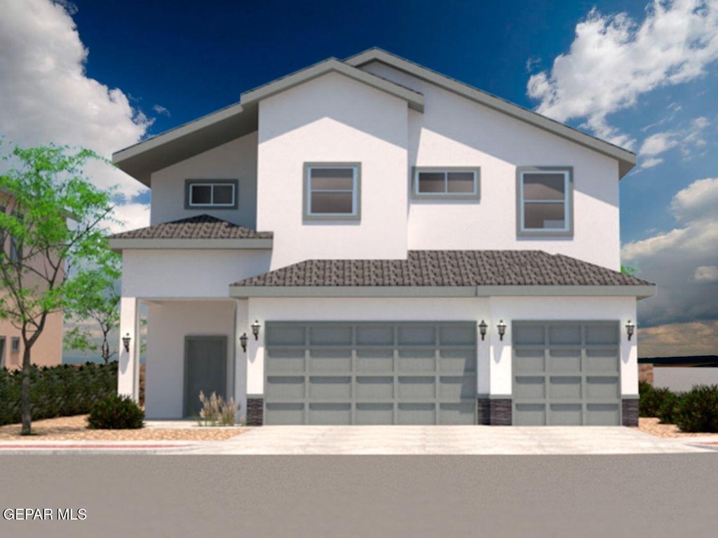 view of front facade with an attached garage, stucco siding, and driveway