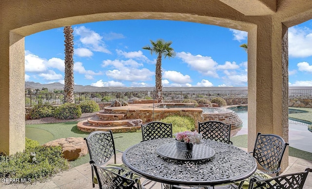 6664 Tuscany Ridge Dr, El Paso, TX 79912 - fenced backyard featuring an outdoor hot tub, outdoor dining space, a patio area, a putting green, and a mountain view