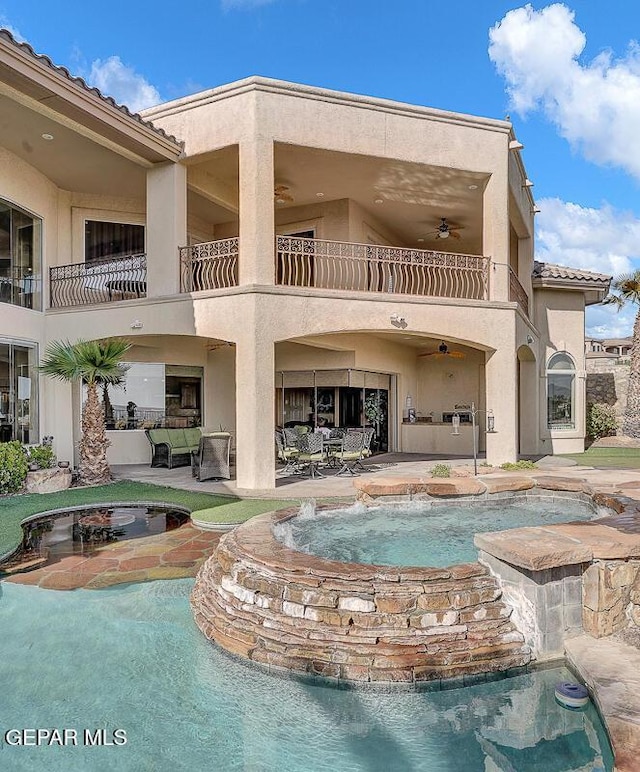 6664 Tuscany Ridge Dr, El Paso, TX 79912 - back of house with a balcony, an in-ground hot tub, stucco siding, and a patio