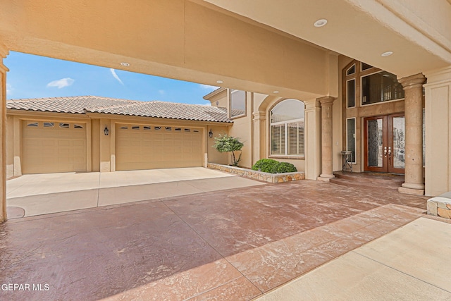 6664 Tuscany Ridge Dr, El Paso, TX 79912 - view of patio featuring french doors, concrete driveway, and a garage
