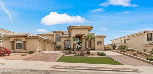 6664 Tuscany Ridge Dr, El Paso, TX 79912 - mediterranean / spanish home with driveway, stucco siding, a garage, and a tile roof
