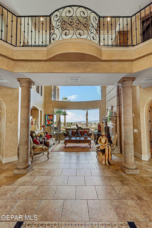 6664 Tuscany Ridge Dr, El Paso, TX 79912 - entrance foyer with decorative columns, a towering ceiling, and stone tile flooring