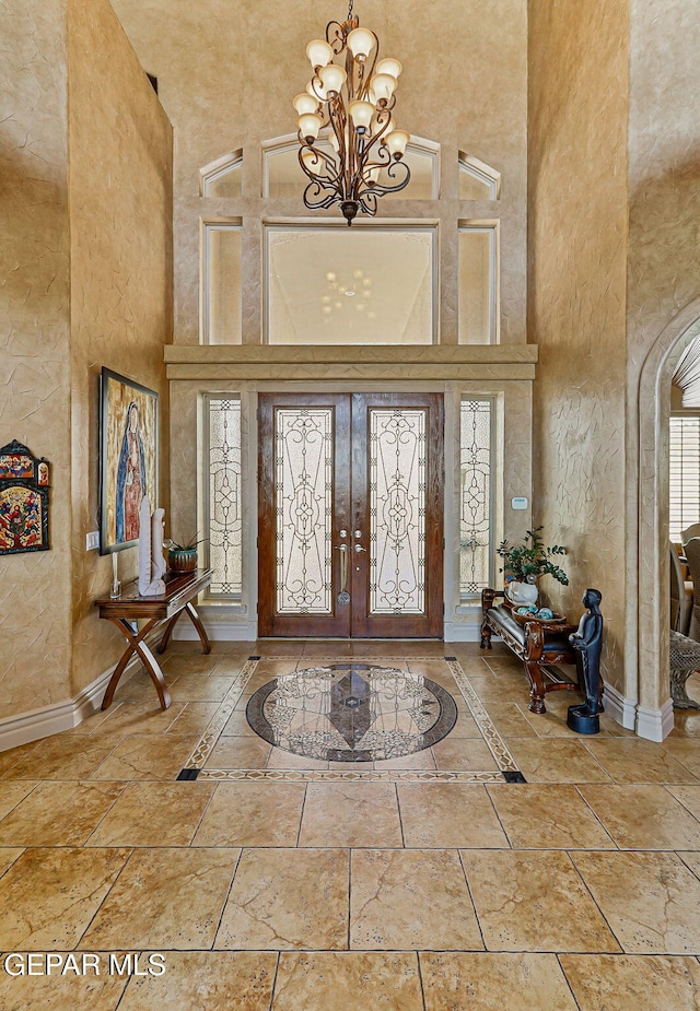 6664 Tuscany Ridge Dr, El Paso, TX 79912 - foyer featuring a towering ceiling, a chandelier, french doors, baseboards, and a textured wall