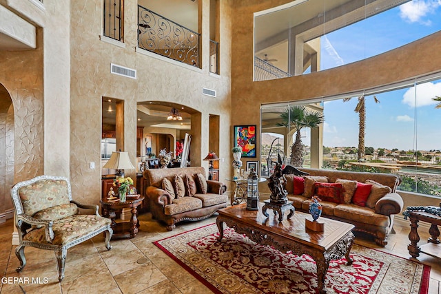 6664 Tuscany Ridge Dr, El Paso, TX 79912 - living area featuring arched walkways, a high ceiling, and stone finish flooring