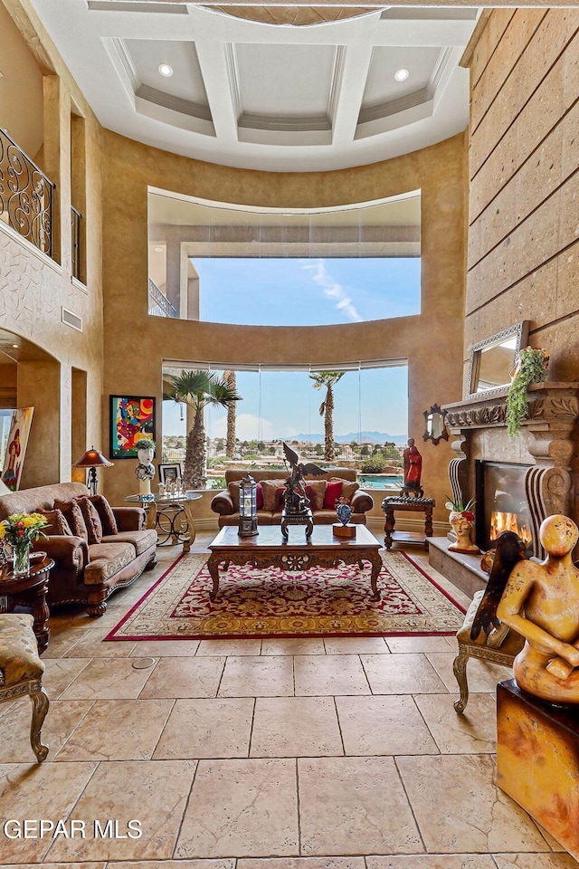 6664 Tuscany Ridge Dr, El Paso, TX 79912 - living room with a towering ceiling, coffered ceiling, a fireplace, beamed ceiling, and stone tile flooring