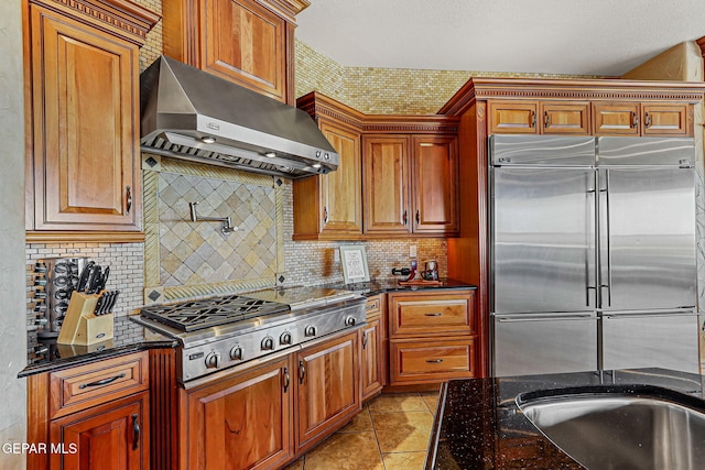 6664 Tuscany Ridge Dr, El Paso, TX 79912 - kitchen featuring stainless steel appliances, range hood, decorative backsplash, dark stone countertops, and light tile patterned floors