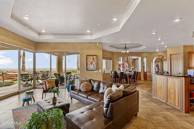 6664 Tuscany Ridge Dr, El Paso, TX 79912 - living area featuring a raised ceiling, arched walkways, a chandelier, crown molding, and recessed lighting