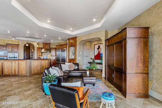6664 Tuscany Ridge Dr, El Paso, TX 79912 - living room featuring arched walkways, a raised ceiling, baseboards, and ornamental molding