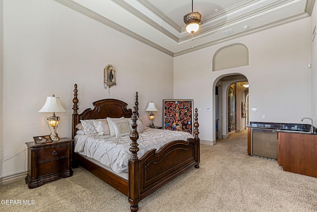 6664 Tuscany Ridge Dr, El Paso, TX 79912 - bedroom featuring arched walkways, ornamental molding, light carpet, a sink, and a tray ceiling