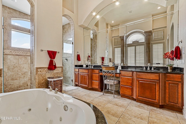 6664 Tuscany Ridge Dr, El Paso, TX 79912 - full bathroom featuring a shower stall, vanity, a jetted tub, tile walls, and a wainscoted wall