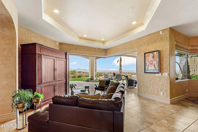 6664 Tuscany Ridge Dr, El Paso, TX 79912 - living room with a textured wall, a tray ceiling, crown molding, a textured ceiling, and baseboards