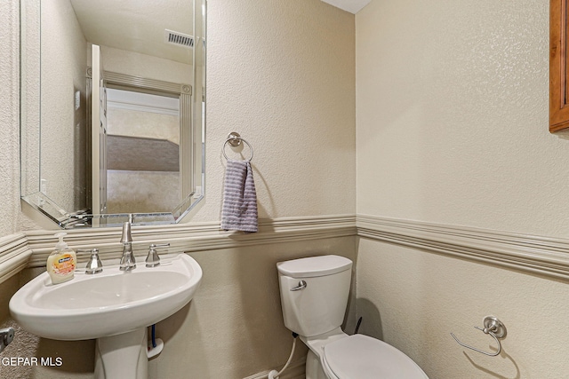 6664 Tuscany Ridge Dr, El Paso, TX 79912 - half bath with toilet, a sink, and a textured wall