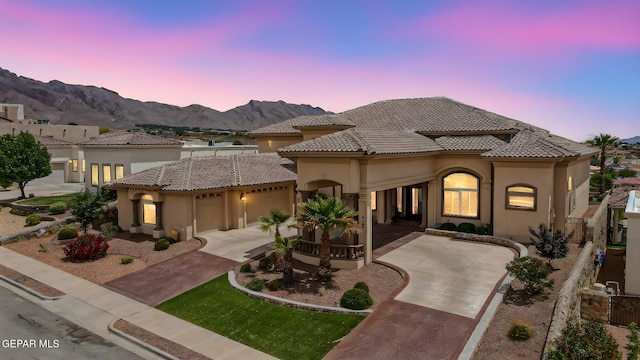 6664 Tuscany Ridge Dr, El Paso, TX 79912 - mediterranean / spanish-style house with stucco siding, a garage, concrete driveway, a mountain view, and a tiled roof