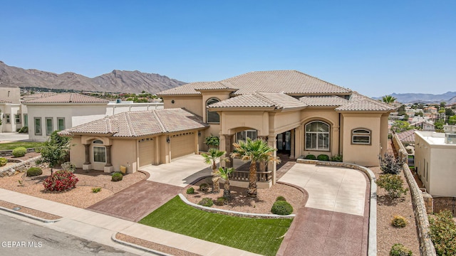 6664 Tuscany Ridge Dr, El Paso, TX 79912 - mediterranean / spanish house with concrete driveway, an attached garage, stucco siding, and a tiled roof