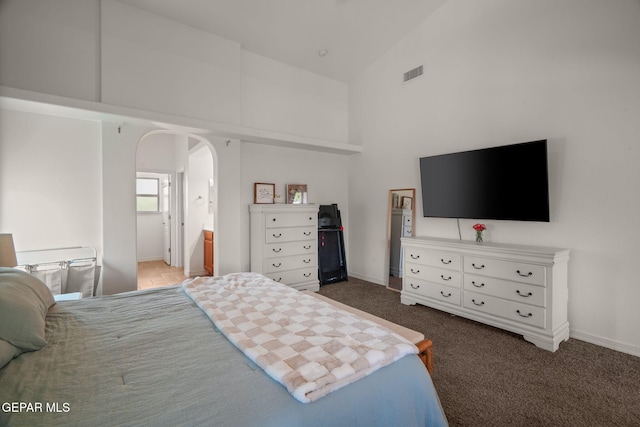14328 N Cave Dr, El Paso, TX 79938 - carpeted bedroom featuring high vaulted ceiling, arched walkways, baseboards, and ensuite bathroom