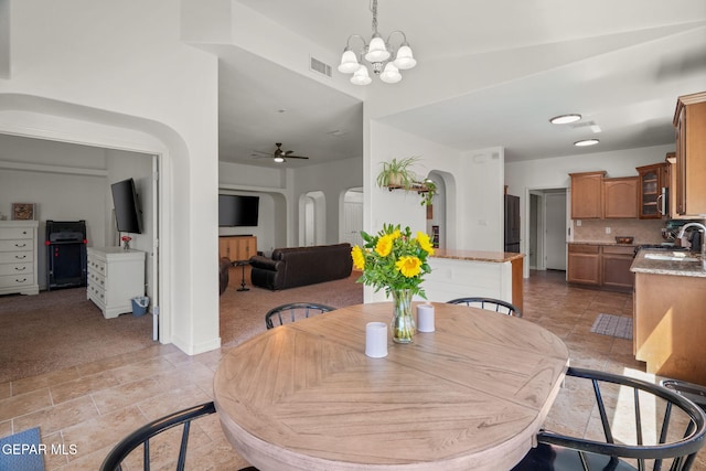 14328 N Cave Dr, El Paso, TX 79938 - dining space with arched walkways, light carpet, a chandelier, and a ceiling fan