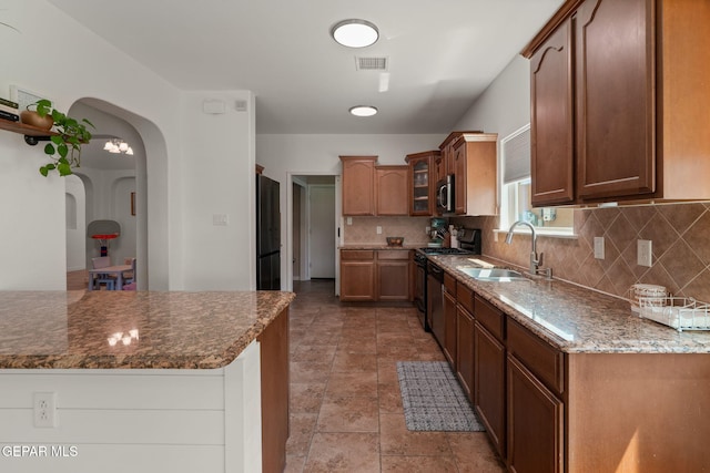 14328 N Cave Dr, El Paso, TX 79938 - kitchen with gas range oven, a sink, freestanding refrigerator, stainless steel microwave, and tasteful backsplash