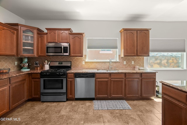 14328 N Cave Dr, El Paso, TX 79938 - kitchen featuring appliances with stainless steel finishes, a sink, light stone countertops, backsplash, and glass insert cabinets