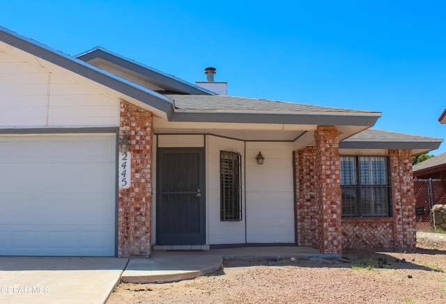 2445 Nancy Mcdonald Dr, El Paso, TX 79936 - view of exterior entry featuring brick siding, a garage, covered porch, and roof with shingles