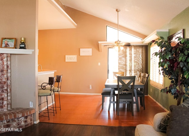 2445 Nancy Mcdonald Dr, El Paso, TX 79936 - dining space featuring lofted ceiling, baseboards, a brick fireplace, wood finished floors, and a ceiling fan