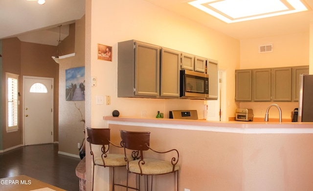 2445 Nancy Mcdonald Dr, El Paso, TX 79936 - kitchen with stainless steel appliances, a sink, light countertops, a breakfast bar, and a peninsula