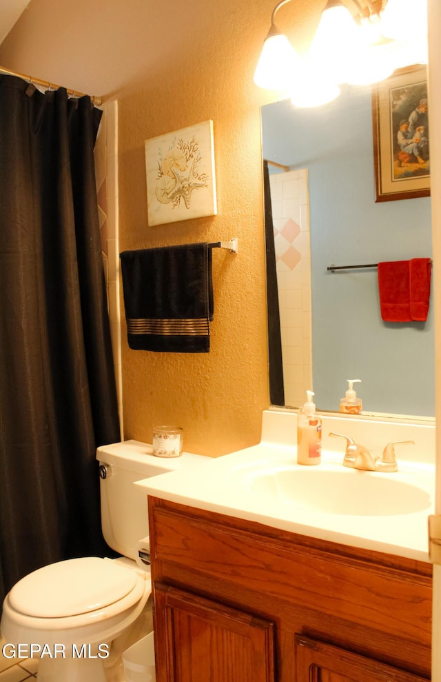 2445 Nancy Mcdonald Dr, El Paso, TX 79936 - bathroom featuring a textured wall, toilet, vanity, and curtained shower