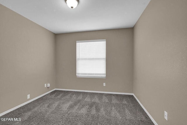 carpeted spare room with baseboards