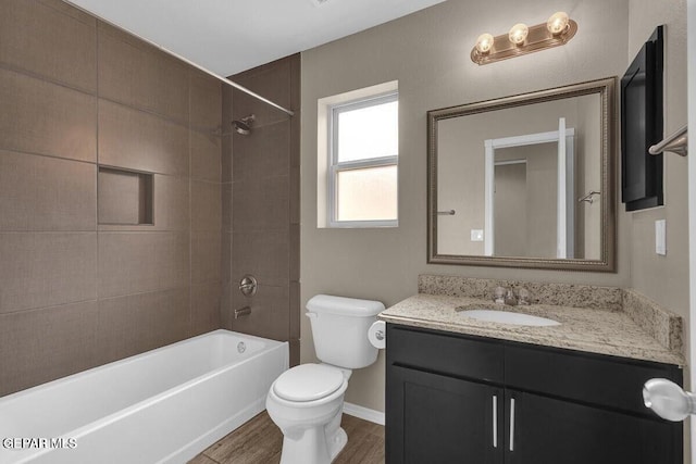 bathroom featuring toilet, wood finished floors, vanity, bathtub / shower combination, and baseboards