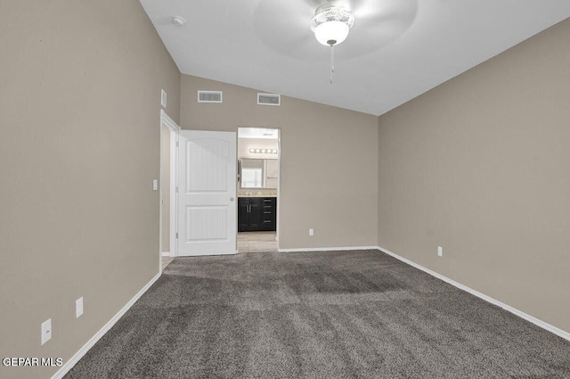 carpeted empty room with a ceiling fan, lofted ceiling, and baseboards