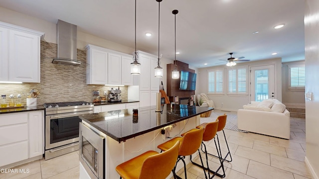 332 Vin Almoradi Ct, El Paso, TX 79912 - kitchen with stainless steel appliances, wall chimney exhaust hood, open floor plan, ceiling fan, and tasteful backsplash