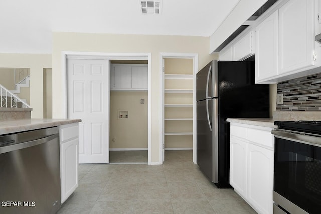 191 Mulberry Ave Unit G, El Paso, TX 79932 - kitchen with appliances with stainless steel finishes, backsplash, white cabinets, light countertops, and baseboards