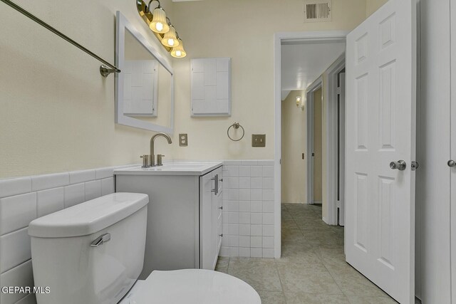 191 Mulberry Ave Unit G, El Paso, TX 79932 - bathroom with tile walls, toilet, wainscoting, vanity, and tile patterned flooring