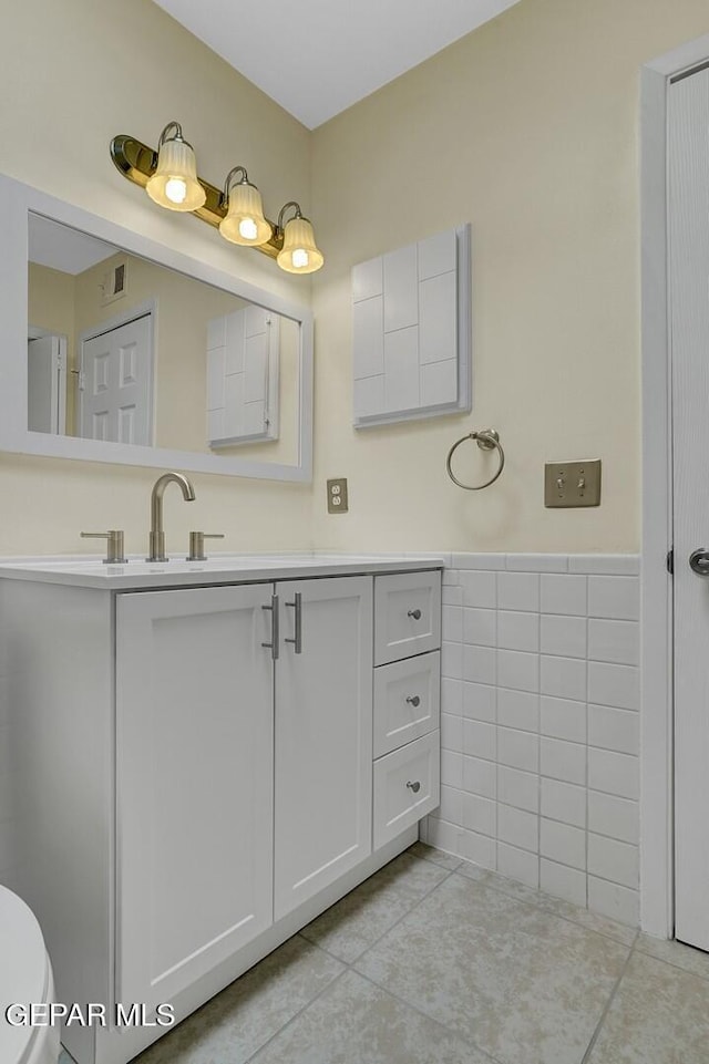 191 Mulberry Ave Unit G, El Paso, TX 79932 - bathroom featuring tile patterned floors, tile walls, vanity, a wainscoted wall, and toilet