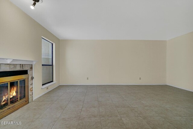 191 Mulberry Ave Unit G, El Paso, TX 79932 - unfurnished living room with a high end fireplace, light tile patterned floors, and baseboards