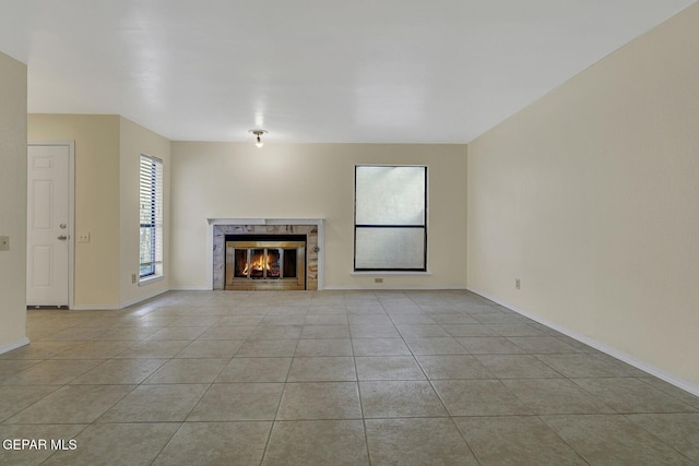 191 Mulberry Ave Unit G, El Paso, TX 79932 - unfurnished living room featuring a fireplace, light tile patterned floors, and baseboards