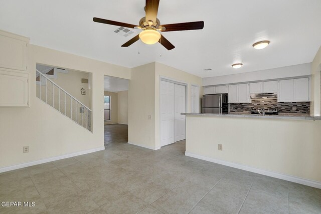 191 Mulberry Ave Unit G, El Paso, TX 79932 - kitchen featuring freestanding refrigerator, under cabinet range hood, a peninsula, ceiling fan, and light tile patterned floors