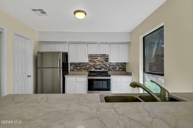 191 Mulberry Ave Unit G, El Paso, TX 79932 - kitchen featuring stainless steel appliances, under cabinet range hood, a sink, light stone countertops, and white cabinets