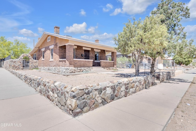 4301 Hueco Ave, El Paso, TX 79903 - view of front of home with brick siding, a porch, a chimney, and fence