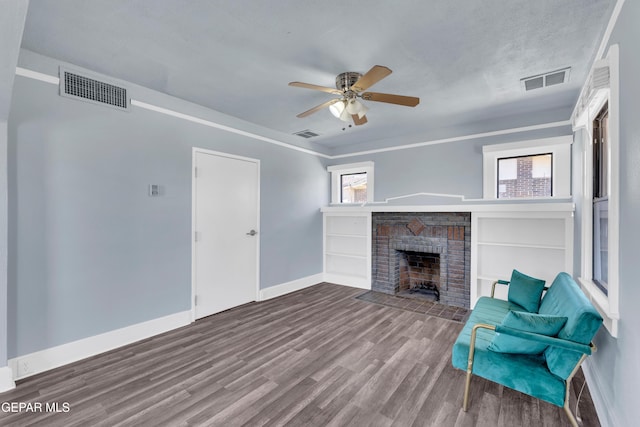 4301 Hueco Ave, El Paso, TX 79903 - living area featuring baseboards, wood finished floors, a ceiling fan, and a brick fireplace