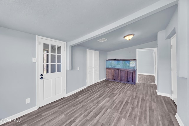 4301 Hueco Ave, El Paso, TX 79903 - unfurnished living room with wood finished floors, baseboards, and a textured ceiling