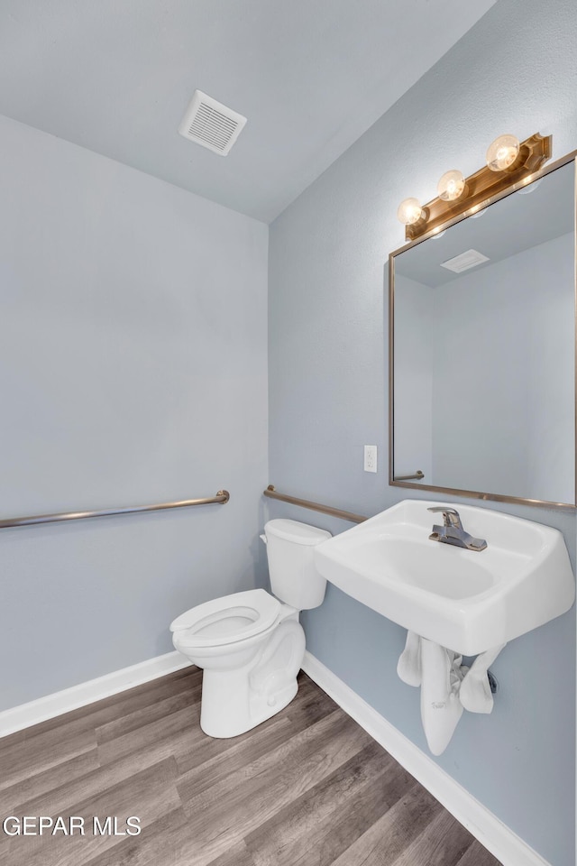 4301 Hueco Ave, El Paso, TX 79903 - half bathroom with toilet, baseboards, and wood finished floors