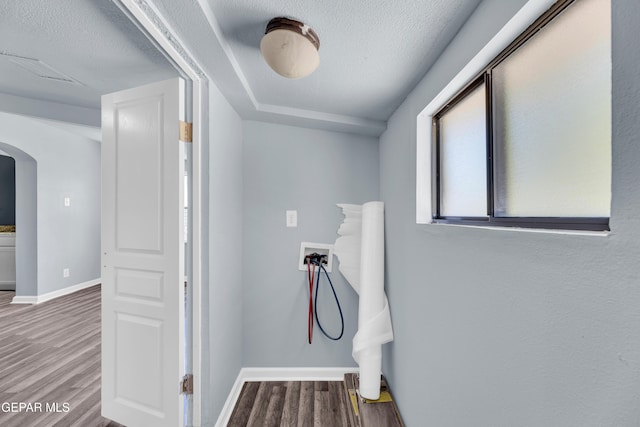 4301 Hueco Ave, El Paso, TX 79903 - laundry area with wood finished floors, baseboards, a textured ceiling, hookup for a washing machine, and arched walkways