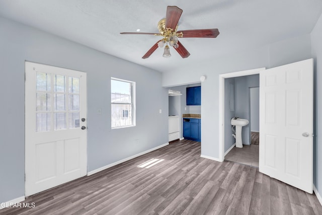 4301 Hueco Ave, El Paso, TX 79903 - unfurnished bedroom featuring wood finished floors, baseboards, connected bathroom, and ceiling fan