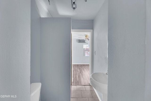 4301 Hueco Ave, El Paso, TX 79903 - bathroom with toilet, tile patterned flooring, a tub, a textured wall, and an AC wall unit