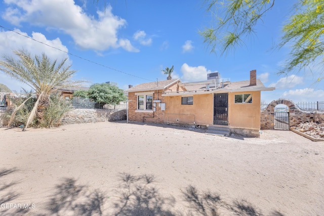 4301 Hueco Ave, El Paso, TX 79903 - rear view of property with a gate, fence, a chimney, and stucco siding