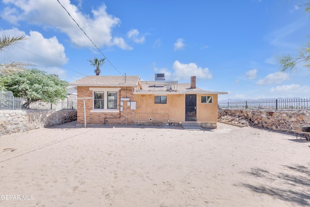4301 Hueco Ave, El Paso, TX 79903 - rear view of house featuring fence, solar panels, a chimney, and brick siding