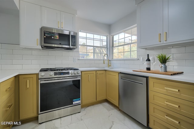7413 Le Conte Dr, El Paso, TX 79912 - kitchen with appliances with stainless steel finishes, a sink, light marble finish flooring, and light countertops